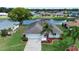 Aerial view showcasing a home on the water with a well-maintained lawn at 609 Fort Duquesna Dr, Sun City Center, FL 33573