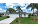 Beautiful home with a well-maintained lawn, palm trees, and a convenient two-car garage at 609 Fort Duquesna Dr, Sun City Center, FL 33573