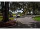 Golf carts driving on a picturesque road lined with mature trees and manicured lawns at 609 Fort Duquesna Dr, Sun City Center, FL 33573