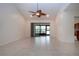 Spacious living room with vaulted ceilings, neutral tile flooring, and sliding glass doors at 609 Fort Duquesna Dr, Sun City Center, FL 33573