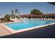 Outdoor community pool with clear blue water and surrounding lounge chairs and tables at 609 Fort Duquesna Dr, Sun City Center, FL 33573