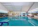 Bright indoor community pool featuring clear blue water, tiled floors, and a beach-themed mural at 609 Fort Duquesna Dr, Sun City Center, FL 33573