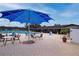 Outdoor community pool with shaded seating areas and a blue umbrella under a partly cloudy sky at 609 Fort Duquesna Dr, Sun City Center, FL 33573
