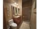 Well-lit bathroom featuring a sink vanity, toilet, and glass-enclosed shower with decorative wall texture at 10626 Restoration Ter, Bradenton, FL 34212