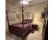 Warm bedroom with a four-poster bed, decorative bedding, and an accent chest of drawers at 10626 Restoration Ter, Bradenton, FL 34212