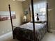 Comfortable bedroom with wrought iron and wood bed frame, bright window, and decorative accents at 10626 Restoration Ter, Bradenton, FL 34212