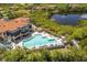 Aerial view of the community pool and clubhouse with waterfront views and beautiful landscaping at 10626 Restoration Ter, Bradenton, FL 34212