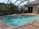 Private outdoor swimming pool and spa surrounded by a screened enclosure and patio area at 10626 Restoration Ter, Bradenton, FL 34212