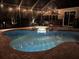 Beautiful pool with a lit-up spa and covered patio at night at 10626 Restoration Ter, Bradenton, FL 34212