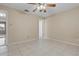 Bright bedroom with a ceiling fan and neutral paint, featuring tiled flooring and an open doorway at 13508 Prestwick Dr, Riverview, FL 33579