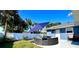 Charming backyard with lush lawn, modern patio seating with sun umbrella, and privacy fence at 3909 W Eden Roc Cir, Tampa, FL 33634