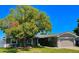 Charming single-story home featuring an attached garage, mature trees, and a well-maintained lawn at 3909 W Eden Roc Cir, Tampa, FL 33634