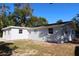 Back exterior view with neutral colored walls, several windows, and grassy yard at 7160 Lenape Cir, New Port Richey, FL 34653