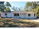 Charming single-story home featuring a well-maintained front yard with mature trees and a freshly painted exterior at 7160 Lenape Cir, New Port Richey, FL 34653
