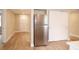 Open kitchen area with stainless steel refrigerator, wood-look floors, and a large closet at 7160 Lenape Cir, New Port Richey, FL 34653