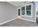 Covered patio features a brick floor, gray siding, and a large window looking to the outdoors at 100 37Th Ne Ave, St Petersburg, FL 33704