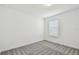 A clean bedroom with neutral carpeting and a window, bathed in soft, natural light at 12811 Wanderlust Pl, Parrish, FL 34219