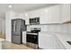 Modern kitchen features white cabinets, stainless steel appliances, and a light counter top at 12811 Wanderlust Pl, Parrish, FL 34219