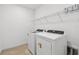 Convenient laundry area with modern washer and dryer, plus overhead shelving for storage at 12811 Wanderlust Pl, Parrish, FL 34219