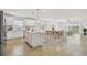 Open concept living room featuring a modern kitchen, dining area, and a sitting space with large windows at 12811 Wanderlust Pl, Parrish, FL 34219