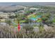 Overhead view of condo building, showing community pool, tennis court, and surrounding landscape at 13215 Slash Pine Dr # H, Hudson, FL 34669
