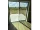 Sliding glass doors offer a view of the flat backyard space from the interior of the home at 2754 Pearly Banks Dr, Bradenton, FL 34208