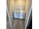 Compact laundry room with white washer and dryer units, plus a wire storage shelf at 2754 Pearly Banks Dr, Bradenton, FL 34208