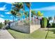 Exterior view of block fence and backyard featuring mature palm trees providing shade and privacy at 5606 Seagrass Pl, Apollo Beach, FL 33572