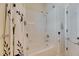 White tiled shower and tub combination with decorative shower curtain and chrome fixtures at 5606 Seagrass Pl, Apollo Beach, FL 33572