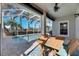 Covered patio with pool and outdoor seating surrounded by tropical landscaping at 5606 Seagrass Pl, Apollo Beach, FL 33572
