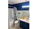 Charming bathroom with stylish navy cabinets, cheerful fish decor, and tub with patterned curtain at 100 Bluff View Dr # 205C, Belleair Bluffs, FL 33770