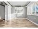 Bright bedroom with wood-look floors, neutral walls, and natural light from two windows at 100 Bluff View Dr # 205C, Belleair Bluffs, FL 33770