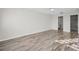 Open bedroom with wood-look floors, neutral walls, and doors to the bathroom and closet at 100 Bluff View Dr # 205C, Belleair Bluffs, FL 33770