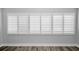 Bright bedroom with window shutters and wood flooring at 100 Bluff View Dr # 205C, Belleair Bluffs, FL 33770