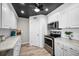 Bright kitchen featuring stainless steel appliances, sleek white cabinetry, and modern countertops at 100 Bluff View Dr # 205C, Belleair Bluffs, FL 33770