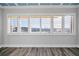 Bright living room features shuttered windows with serene water views, and attractive wood-look flooring at 100 Bluff View Dr # 205C, Belleair Bluffs, FL 33770