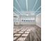 A bright living room featuring a unique blue coffered ceiling, complemented by stylish flooring and ample natural light at 100 Bluff View Dr # 205C, Belleair Bluffs, FL 33770
