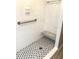 Newly renovated shower with white subway tile and stylish black and white mosaic floor at 100 Bluff View Dr # 205C, Belleair Bluffs, FL 33770