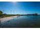 Scenic community water access with a sandy beach, grassy area, and an adjacent bridge for convenient travel at 100 Bluff View Dr # 205C, Belleair Bluffs, FL 33770