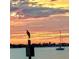 Scenic waterfront view with colorful sunrise, sailboat, and heron perched on a channel marker at 100 Bluff View Dr # 205C, Belleair Bluffs, FL 33770