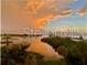 Scenic sunset reflecting on the water's edge amid palm trees at 100 Bluff View Dr # 205C, Belleair Bluffs, FL 33770