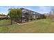 Lush backyard with a screened-in patio area, manicured landscaping, and privacy fence at 11910 Climbing Fern Ave, Riverview, FL 33579