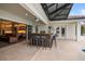 Covered outdoor kitchen boasts countertop seating and views to the pool and indoor kitchen at 11910 Climbing Fern Ave, Riverview, FL 33579