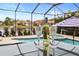 Poolside table with white wine and glasses offer serene views of the pool and pond at 11910 Climbing Fern Ave, Riverview, FL 33579