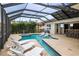 Screened in pool with sun shelves, hot tub, outdoor lighting and views of the pond at 11910 Climbing Fern Ave, Riverview, FL 33579