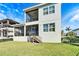 View of a two-story home with a screened-in porch, outdoor stairs, and a well-maintained lawn at 1308 Alhambra Dr, Apollo Beach, FL 33572