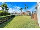 Spacious backyard featuring a waterfront view, lush green grass, and tropical palm trees, perfect for outdoor enjoyment at 1308 Alhambra Dr, Apollo Beach, FL 33572