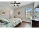 Bright bedroom featuring hardwood floors, closet, and window with plantation shutters at 1308 Alhambra Dr, Apollo Beach, FL 33572