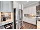 Modern kitchen with stainless steel refrigerator, granite countertops, and custom backsplash tiling at 1308 Alhambra Dr, Apollo Beach, FL 33572