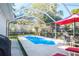 Screened-in pool area with patio seating, red accents, and lush landscaping at 1926 Burlington N Ave, St Petersburg, FL 33713